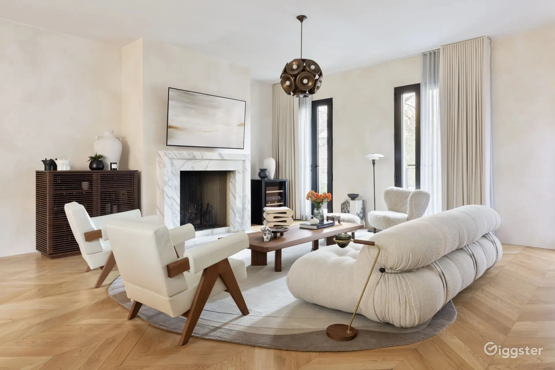 A hotel room with a couch , table , chairs and a bed.